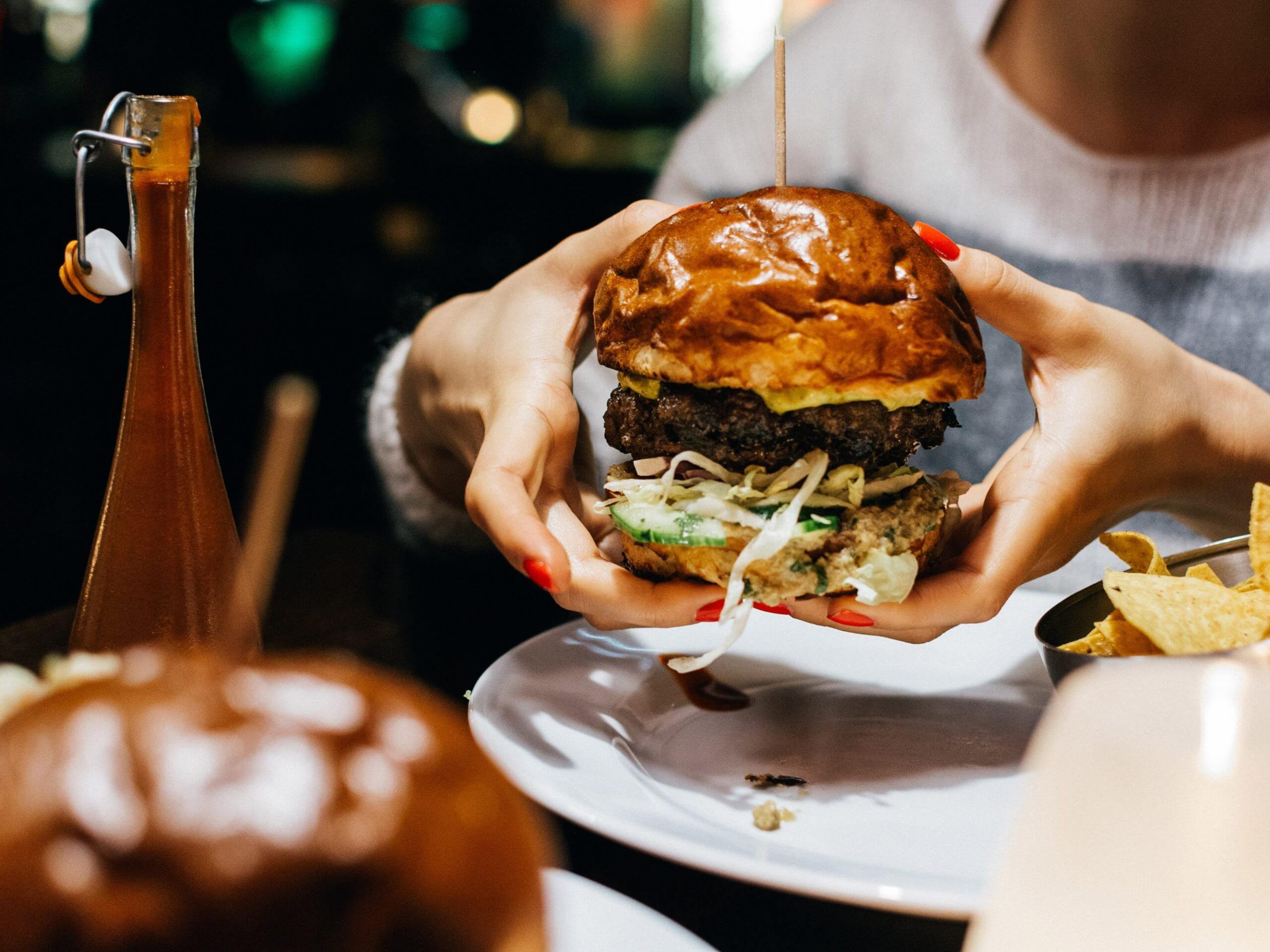 Girl holding a juicy beef burger